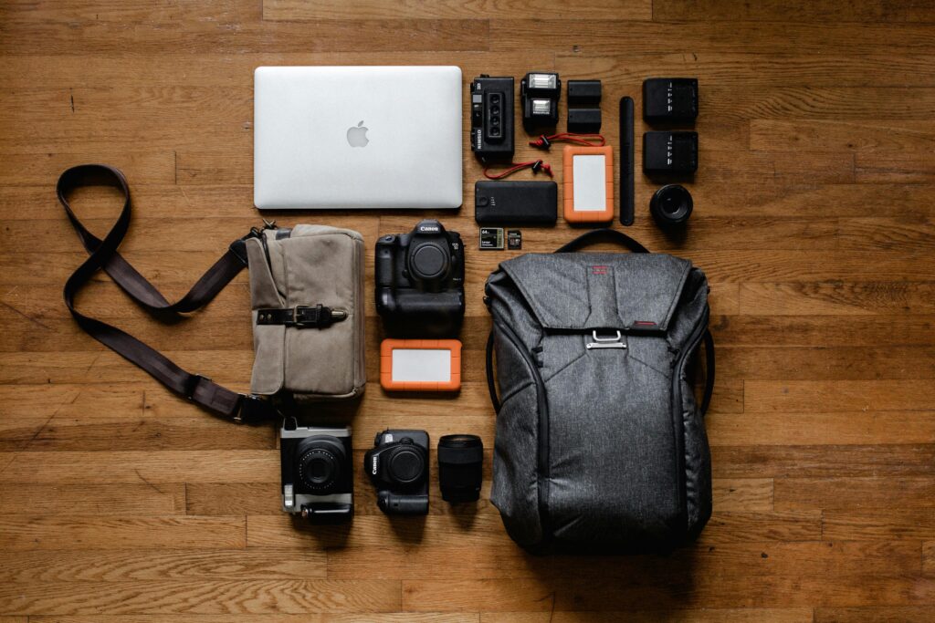 Smartphones, cameras, bags and laptop on top of a wooden table as the best gadgets 2026