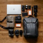 Smartphones, cameras, bags and laptop on top of a wooden table as the best gadgets 2026
