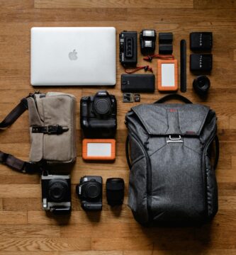Smartphones, cameras, bags and laptop on top of a wooden table as the best gadgets 2026