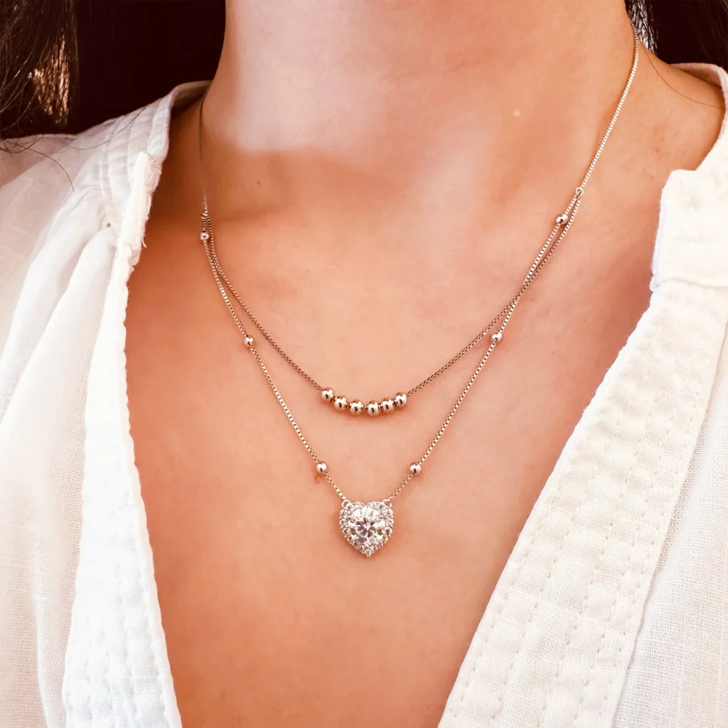 Beautiful model wearing Classic teardrop moissanite pendant hanging from a delicate silver necklace