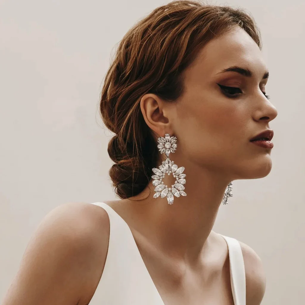 Beautiful model wearing a pair of statement diamond stud earrings reflecting light, symbolizing luxury and permanence.