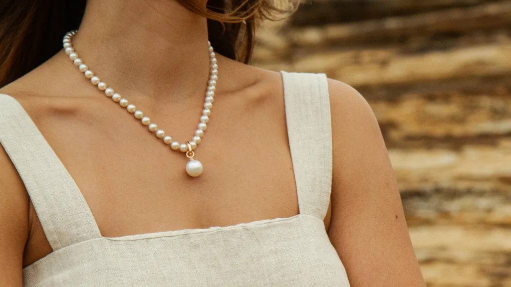 Strand of high-luster white Akoya pearl necklace with a 14k gold filigree clasp.