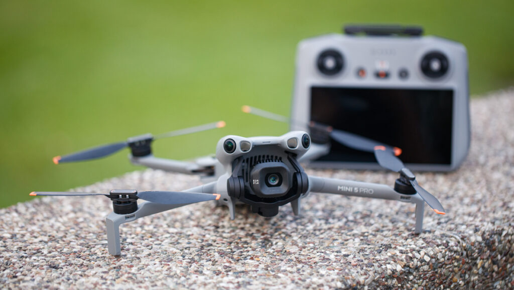 Creator Gear Guide 2026: Best Cameras, Streaming & Creator Setups 5 Dji mini 5 pro with remote on cement, with green grass behind.