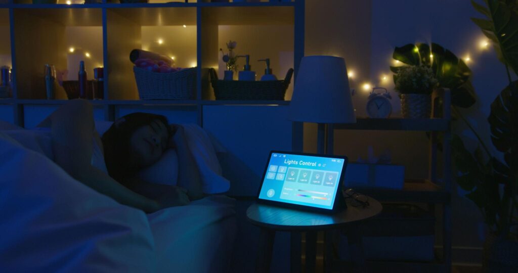 Sleep Tech: The Smart 2026 Bedroom Revolution for Deeper, Restorative Sleep. 8 Smart bedroom sleep tech setup with automated lighting control tablet, ambient night lighting, and relaxing sleep environment for deeper restorative sleep