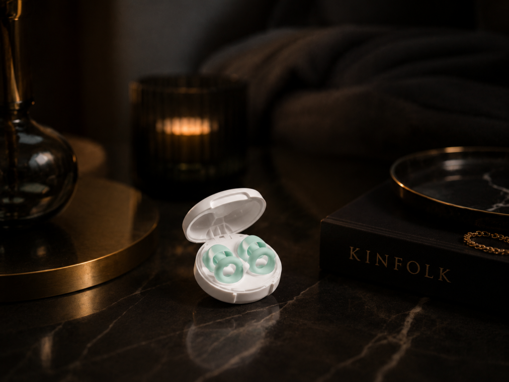 Loop Quiet 2 earplugs displayed in an elegant luxury setting on a dark marble table with premium décor, showcasing the reusable sleep earplugs and carrying case.