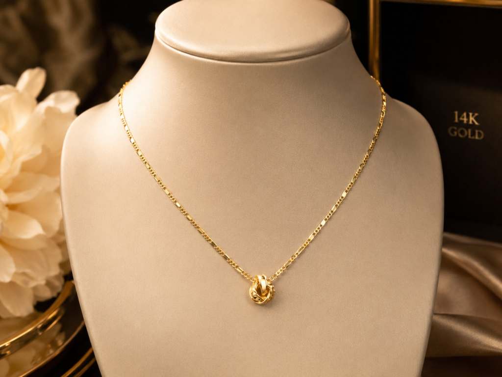 14k gold necklace displayed on a luxury jewelry bust with a delicate gold chain and elegant pendant in a warm premium setting.